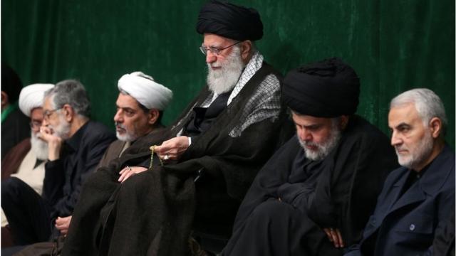 مقتدي الصدر جالساً إلى جوار المرشد الأعلى للثورة الإيرانية علي خامنئي وقائد فيلق القدس قاسم سليماني