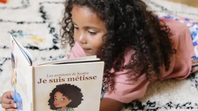 Scottie lit le livre 'Je suis metisse'