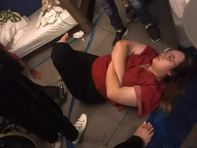 "รุ้ง ปนัสยา" ทิ้งตัวนอนลงบนพื้นในห้องพักของโรงแรมเพื่อเป็นการแสดงอารยะขัดขืนขณะเจ้าหน้าที่แสดงหมายจับเพื่อจับกุม