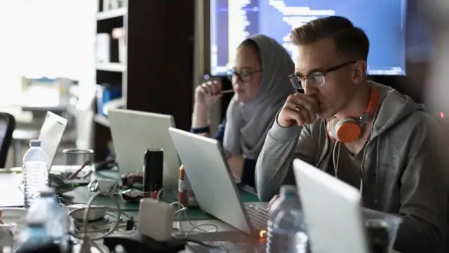 Unas personas trabajando frente a sus computadoras
