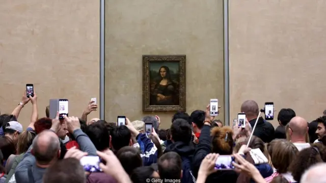 Pessoas fotografam o quadro da Monalisa