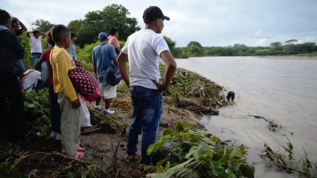Hondureños mirando el río Goascorán.