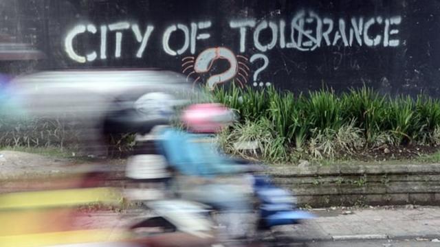 Di sebuah dinding jalan tertulis city of tolerance disertai tanda tanya.