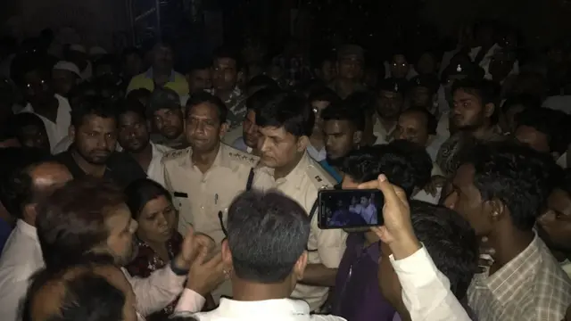 पुलिस अधिकारी ग्रामीणों से बात करते हुए