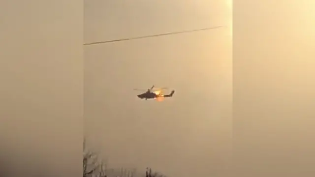A helicopter in flames in the sky