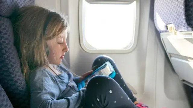 Una niña con una tableta en un avión