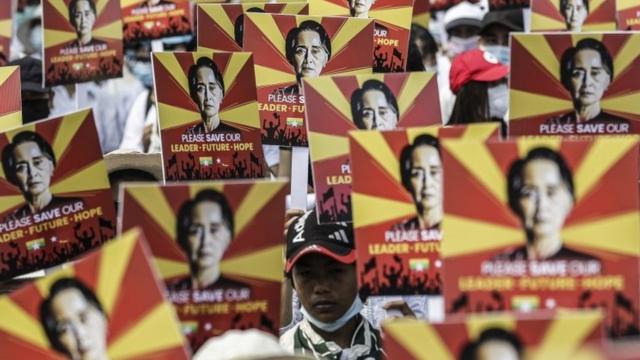 Myanmar protesters hold up images of jailed leader Aung San Suu Kyi