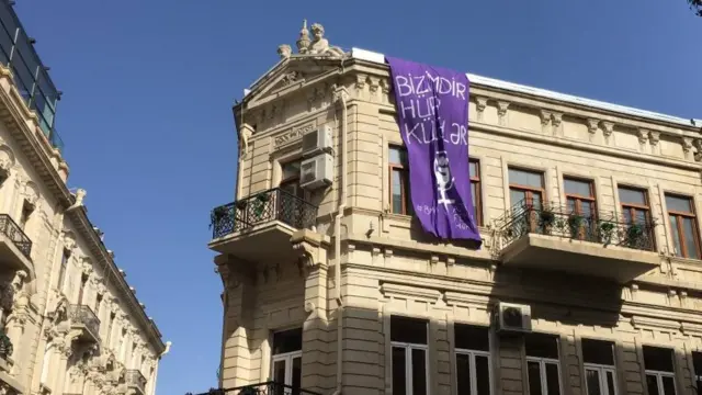 Yürüş başlayanda Nizami küçəsində bir binanın üzərindən 8 marş yürüşünün əsas şüarı asılıb