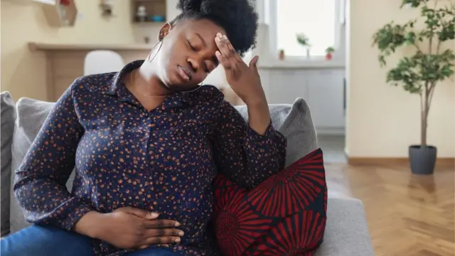 ሆዷን እና ራሷን የያዘች ሴት