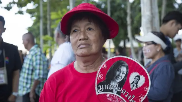 Một người ủng hộ bà Yingluck đứng ngoài Tòa án Tối cao trước phiên tòa về cáo buộc 'sao nhãng bổn phận' của bà hôm 27/9.