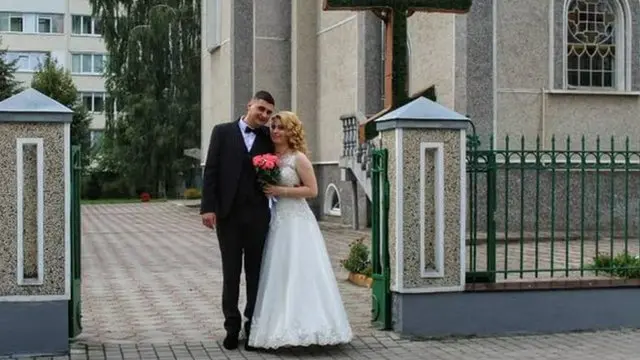 Sladjan and Anna posing in front of a church on their wedding day