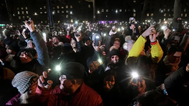 स्मार्ट फ़ोन दिखाते लोग