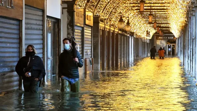 사람들이 물에 잠긴 세이트 마크 광장을 걷고 있다