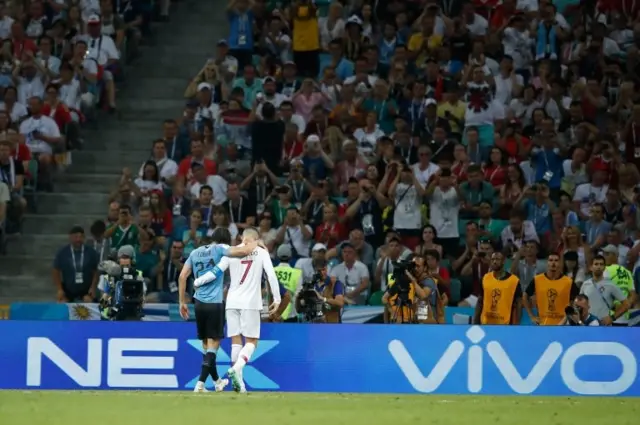 Cavani, lesionado, es ayudado por Ronaldo a salir del campo.