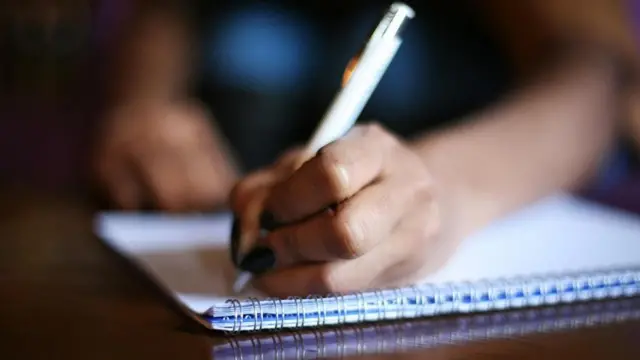 شابة تكتب في كراسة