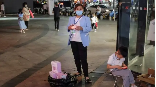 A vendor holds a tory sell at her street stall in Beijing, China, 05 June 2020. China turns to street vendor economy to help manage unemployment crisis that the COVID-19