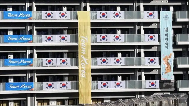 अब खेलगांव में दक्षिण कोरियाई खिलाड़ियों के फ्लैट के बाहर टाइगर वाला बैनर टंगा है