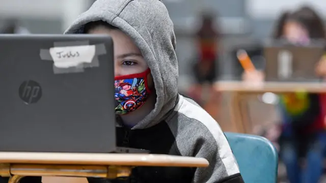 Menino estudando pelo computador