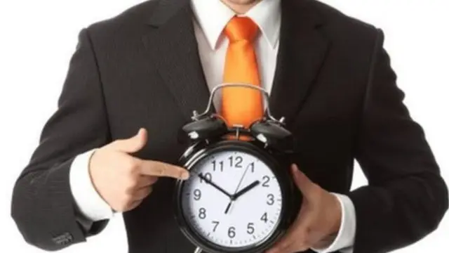 موظف يحمل ساعة تنبيه