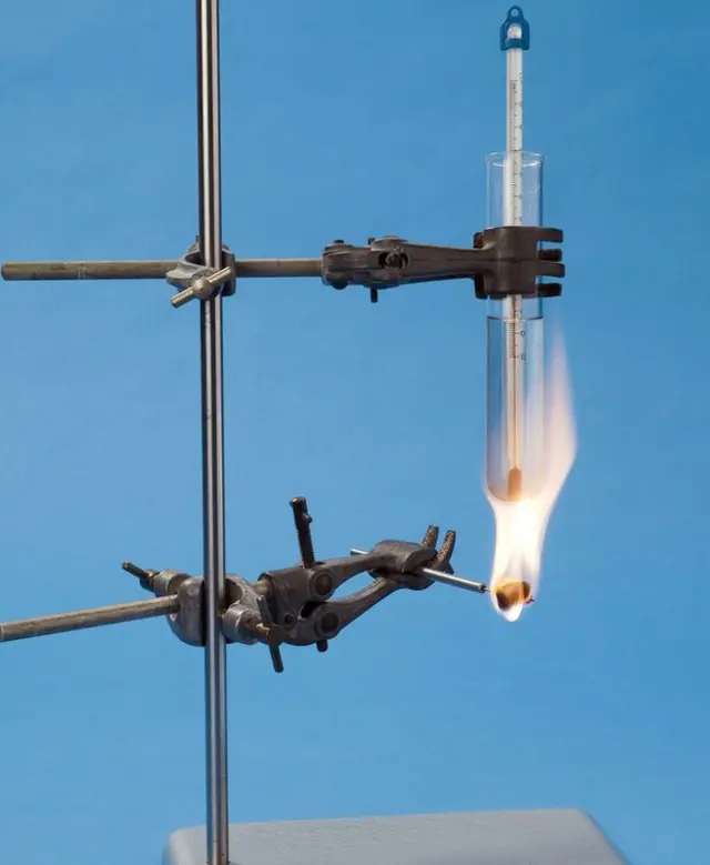 Midiendo el contenido calórico de la comida quemándola. El alimento se prende y el calor que despide aumenta la temperatura del agua que está en el tubo de ensayo. Ese aumento se usa para calcular la cantidad de energía liberada.