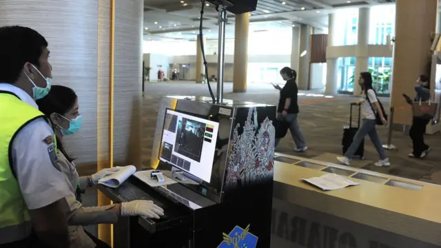 Petugas memantau suhu tubuh penumpang menggunakan alat pemindai suhu tubuh di Terminal Kedatangan Internasional Bandara Internasional I Gusti Ngurah Rai, Bali, Rabu (22/1/2020).