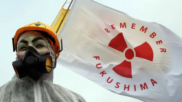 Una persona porta una bandera con la leyenda "Recuerda Fukushima"