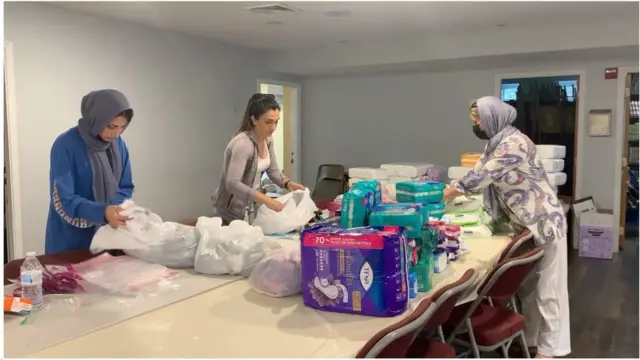 زنان و دختران جوان بدون حجاب اسلامی برای کمک به جابه‌جایی و طبقه‌بندی اجناس اهدایی به مسجدی در آمریکا آمدند