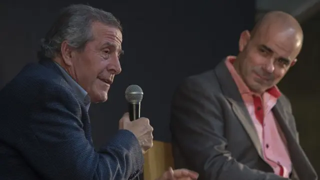 Sacheri (derecha) en una charla junto al director técnico de la selección de Uruguay Óscar Tabárez.