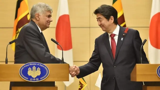 Sri Lankan Prime Minister Ranil Wickremesinghe (L) shakes hands with his Japanese counterpart Shinzo Abe (R) following their joint press announcement at Abe's official residence in Tokyo on October 6, 2015