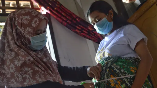 Kader Posyandu mengukur lingkar perut ibu rumah tangga yang tengah menjalani usia kehamilan delapan bulan.