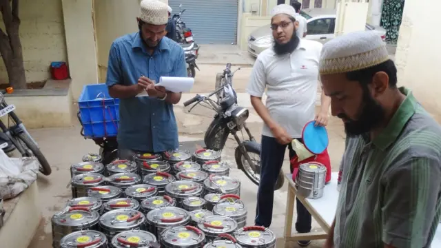 डबे काळजीपूर्वक पोहोचवणारे स्वयंसेवक