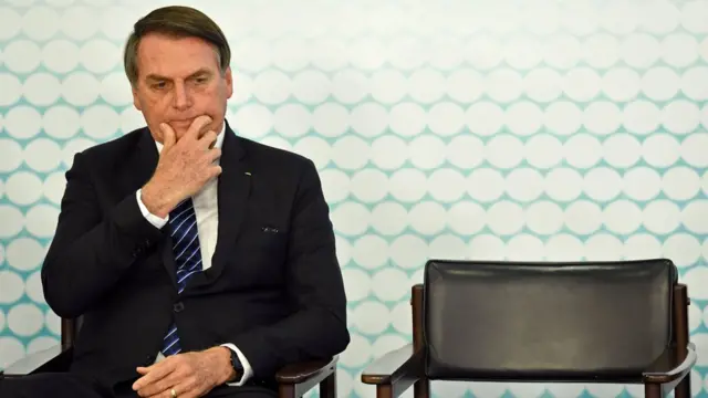 Bolsonaro sentadoplataforma para ganhar dinheiro jogandocadeira durante evento