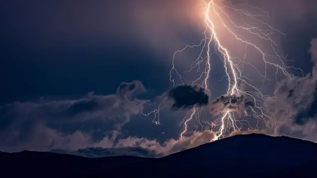 The summit of Tal y Fan is illuminated by lightning. Photo taken from Llansanffraid Glan Conwy by Weather Watcher Grotty.