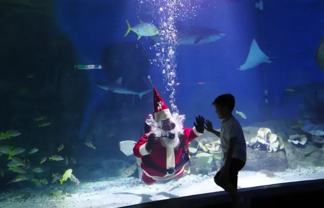 طفل ينظر إلى شخص يرتدي زي بابا نويل