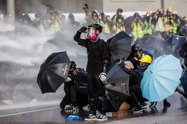 Pro-democracy protesters react as police fire water cannon in Hong Kong in September. The protests started in June over a controversial extradition bill but evolved into broader anti-government demonstrations that have gripped the territory for more than six months.