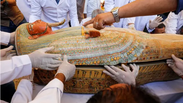 Archaeologists remove the cover of an ancient painted coffin discovered at al-Asasif Necropolis in the Vally of Kings in Luxor, Egypt October 19, 2019