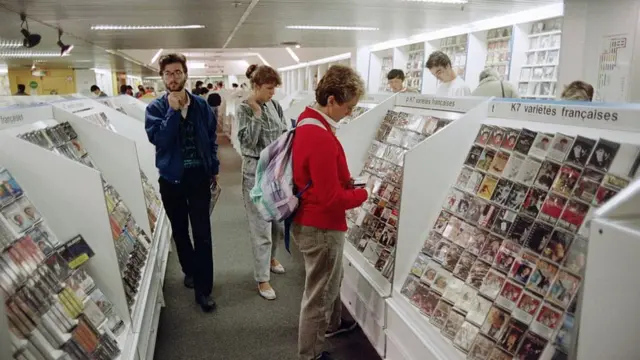 Des clients regardent des cassettes de musique exposées dans un magasin Fnac, le 28 août 1987.