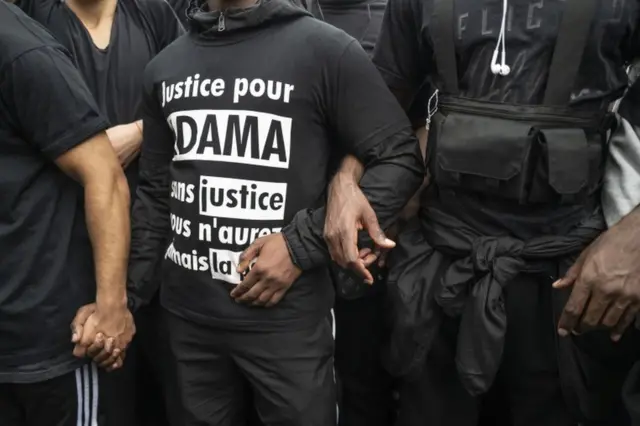 Masu zanga-zanga sun riƙe hannun juna lokacin zanga-zangar adawa da nuna wariyar launin fata ranar 13 ga watan Yuni, 2020 a birnin Paris na Faransa. Ana zanga-zangar ne don nuna goyon baya ga Ba'amurke George Floyd wanda 'yan sanda suka kashe a Minneapolis.