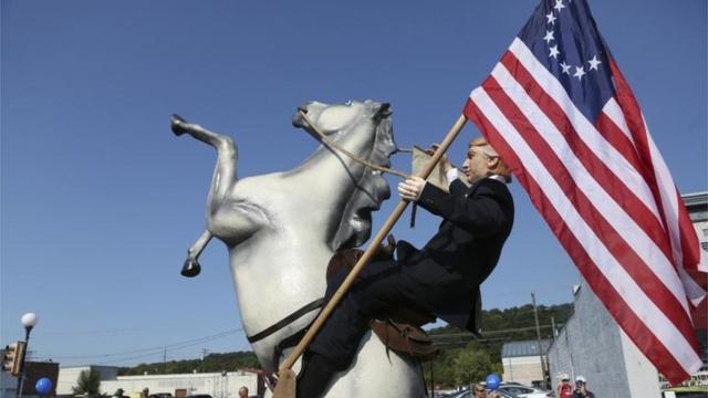 Estatua de Donald Trump sobre un caballo y llevando la bandera Betsy Ross.