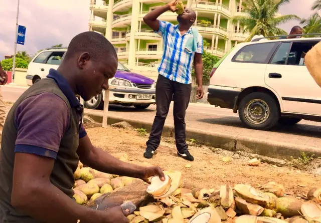 A man cutting coconuts on a street in Libreville, Gabon - Sunday 29 January 2017