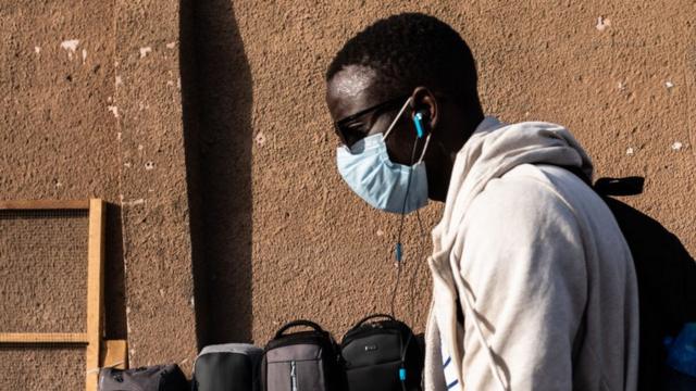 Un jeune homme portant un masque sur le visage pour se protéger du coronavirus à Dakar (Sénégal)