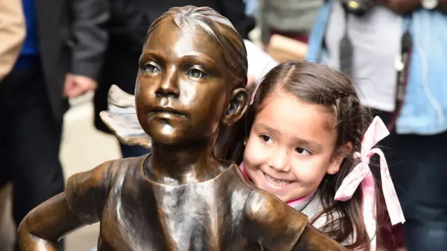 Девочка обнимает статую девочки