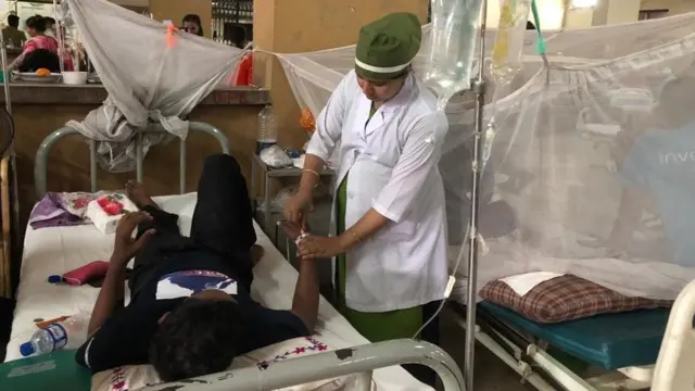 ঢাকার একটি হাসপাতালে ডেঙ্গু আক্রান্ত একজন রোগীকে চিকিৎসা সেবা দিচ্ছেন একজন সেবিকা