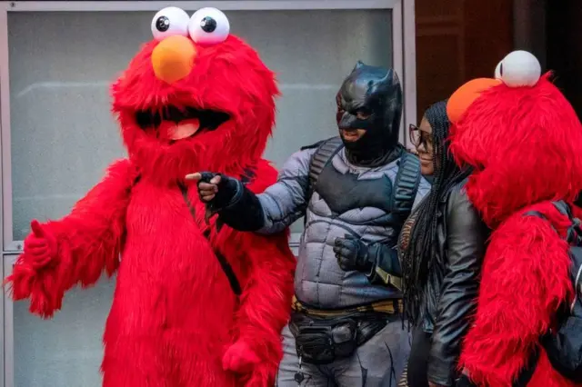 Un hombre disfrazado de Batman y otras dos personas de Elmo en Nueva York en noviembre de 2019.