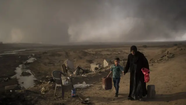 Mulher e criança caminham pelos arredores da cidade