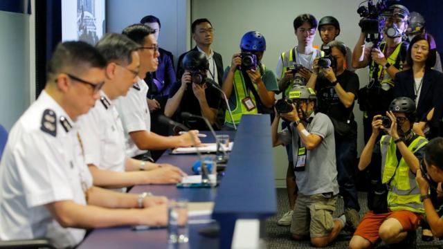 香港警务处处长卢伟聪6月13日举行记者会交代前一日清场行动时，一些记者穿上黄背心，戴上头盔，抗议警方不尊重新闻工作者。