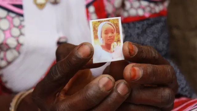La mère d'une fille tient la photo de son enfant et espère la retrouver un jour.