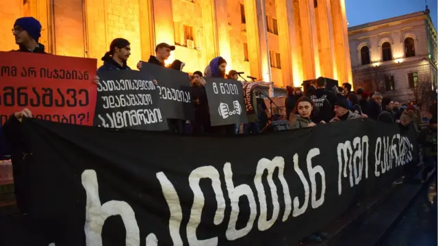 Более десятка активистов держат плакаты