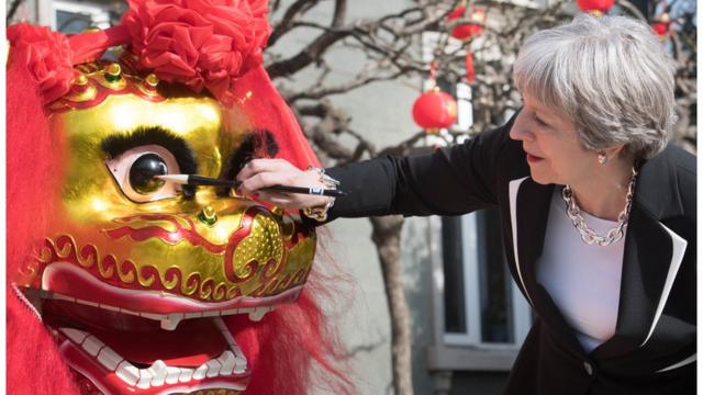 Prime Minister Theresa May "dots the eye" of a Chinese dragon