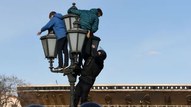 Полицейский лезет на фонарь